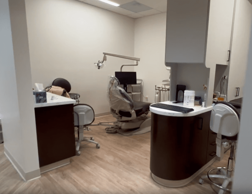 Modern dental operatory with examination chair, overhead light, and computer monitor at Sunnyvale Implant Center, designed for advanced implant procedures.