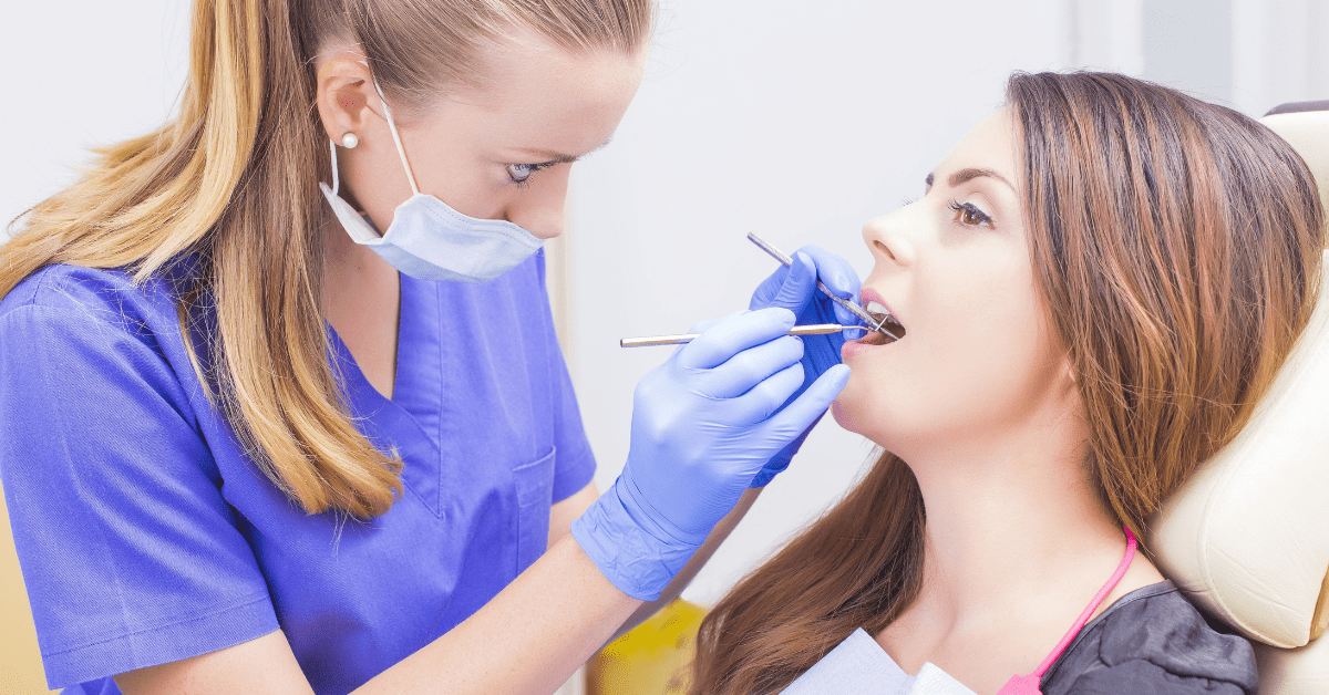 Dental hygienist examining a patient’s teeth during a routine dental checkup.