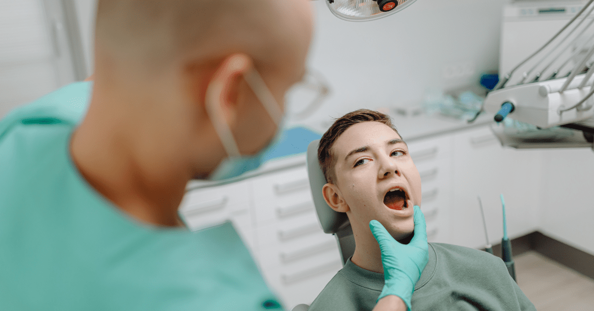 Dentist examining a patient’s mouth during an oral surgery consultation.